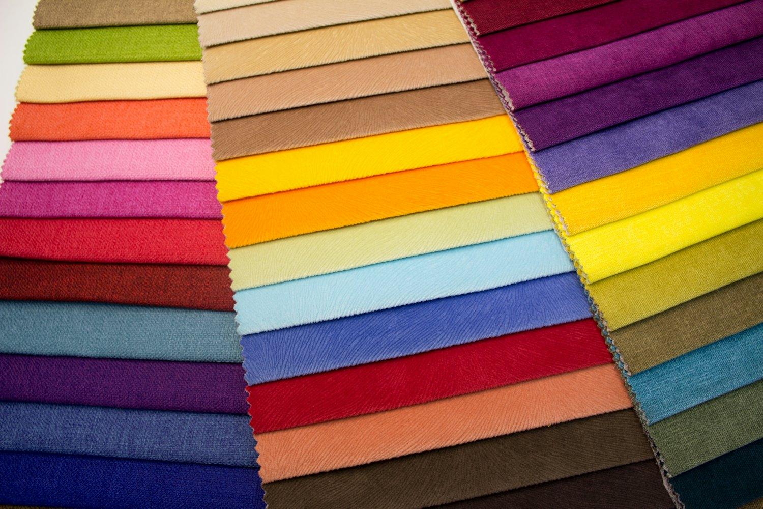 Échantillons de tissus de nombreuses couleurs disposés sur une table